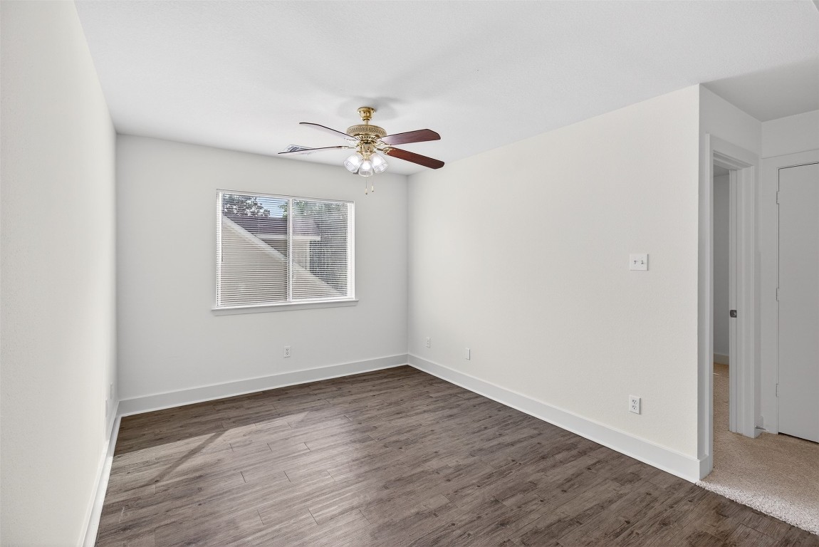 803 Dragonfly Drive Conroe, TX 77301 - Photo 28 of 50 an empty room with wooden floor chandelier fan and windows