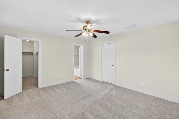 an empty room with a ceiling fan and a window