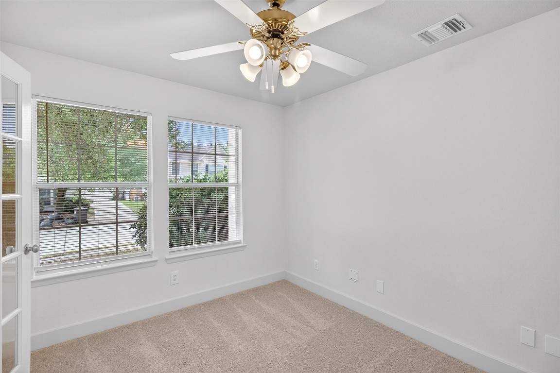803 Dragonfly Drive Conroe, TX 77301 - Photo 9 of 50 an empty room with windows and chandelier fan