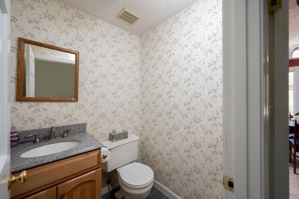 32 Old County Road Hingham, MA 02043 - Photo 16 of 38 a bathroom with a granite countertop toilet a sink and a mirror