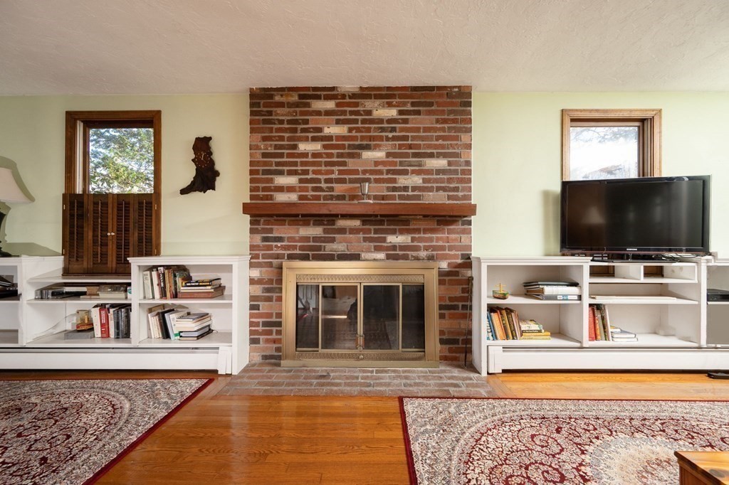 32 Old County Road Hingham, MA 02043 - Photo 18 of 38 a living room with fireplace and a flat screen tv