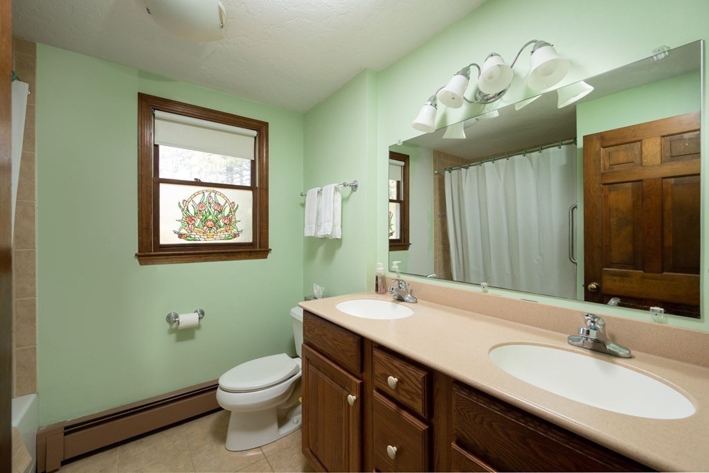 32 Old County Road Hingham, MA 02043 - Photo 27 of 38 a bathroom with a double vanity sink toilet and a mirror