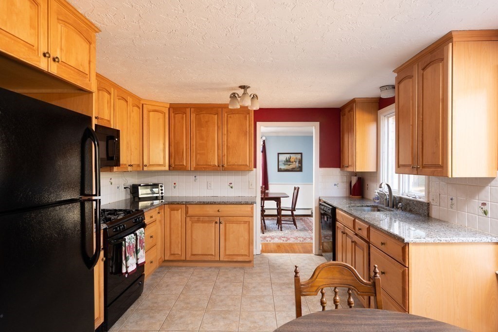 32 Old County Road Hingham, MA 02043 - Photo 6 of 38 a kitchen with stainless steel appliances granite countertop a refrigerator a stove a sink a dining table and chairs