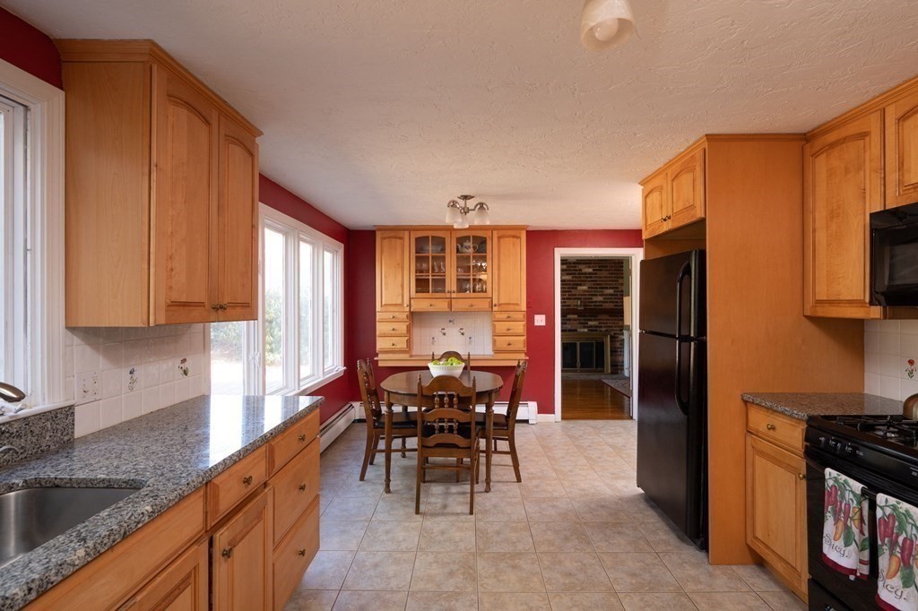 32 Old County Road Hingham, MA 02043 - Photo 9 of 38 a kitchen with granite countertop sink cabinets and outdoor space