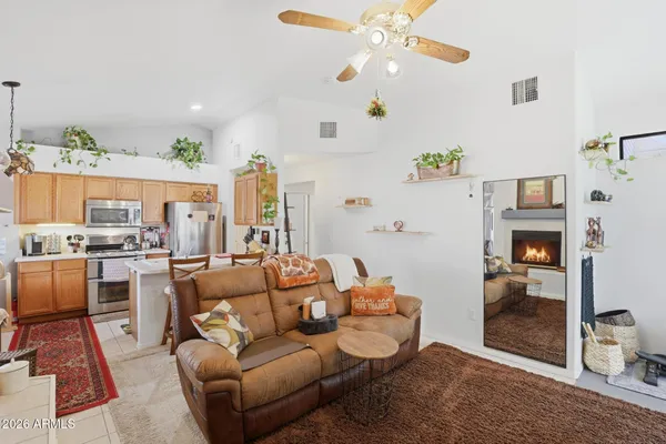 a living room with furniture kitchen view and a chandelier