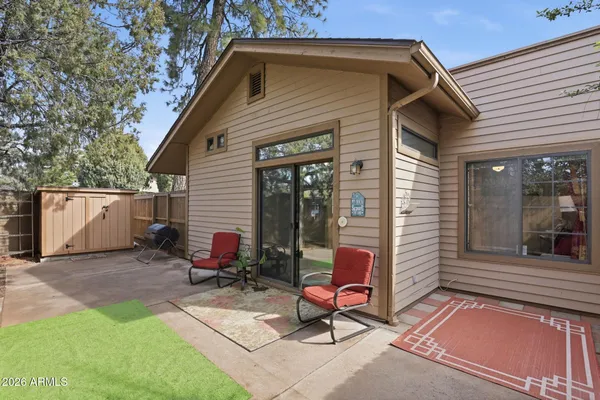a view of a chair and table in backyard of the house