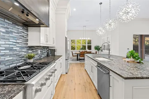 a kitchen with stainless steel appliances granite countertop a sink stove and cabinets