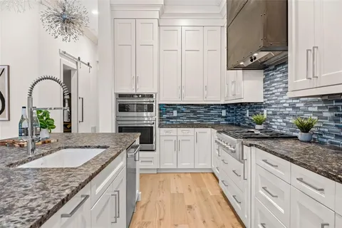 a kitchen with granite countertop a sink stainless steel appliances and cabinets