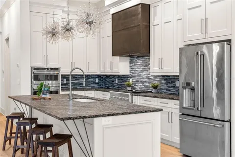 a kitchen with stainless steel appliances granite countertop a sink stove and refrigerator