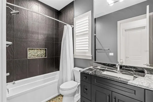 a bathroom with a granite countertop sink toilet and shower