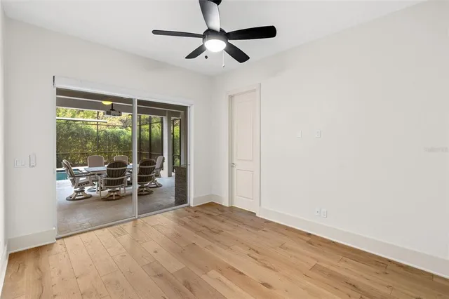 an empty room with floor to ceiling window and wooden floor