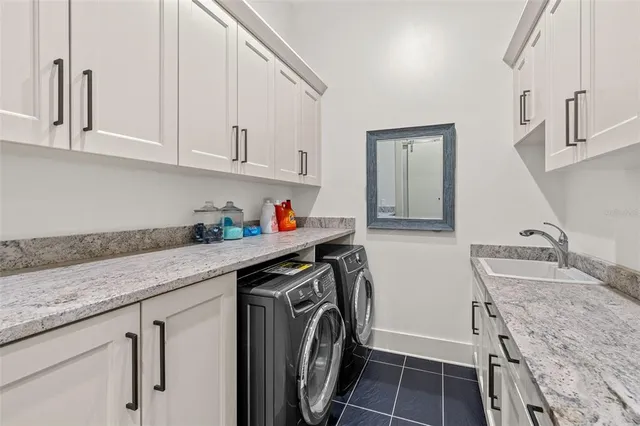 a utility room with granite countertop a sink a washer and dryer