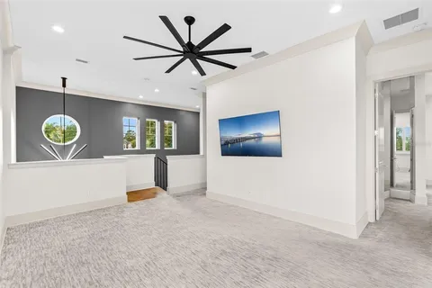 wooden floor in a hall with a window and a chandelier