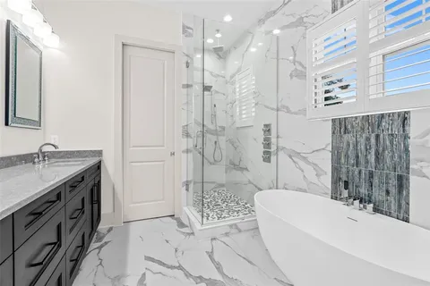 a bathroom with a granite countertop sink a toilet a mirror and shower
