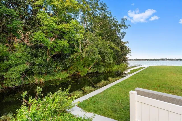 a view of a green yard with a lake view
