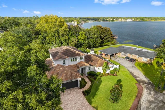 an aerial view of a house with outdoor space and a lake view