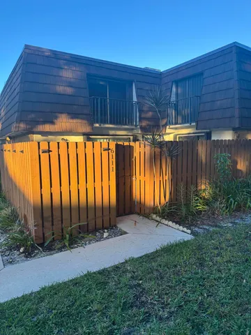 a view of backyard with potted plants and wooden fence