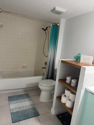a bathroom with a toilet and a shower