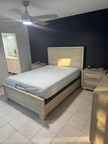 a bedroom with a bed and a flat tv screen on dresser