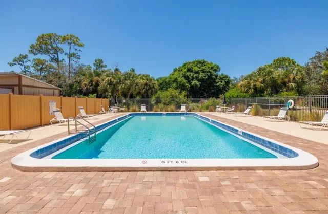 a backyard of a house with plants and large trees