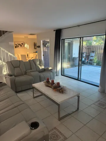 a living room with furniture and a floor to ceiling window
