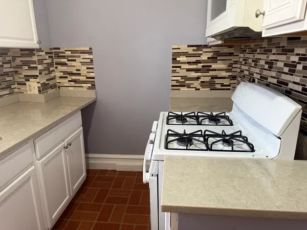 a kitchen with wooden cabinets and a stove top oven