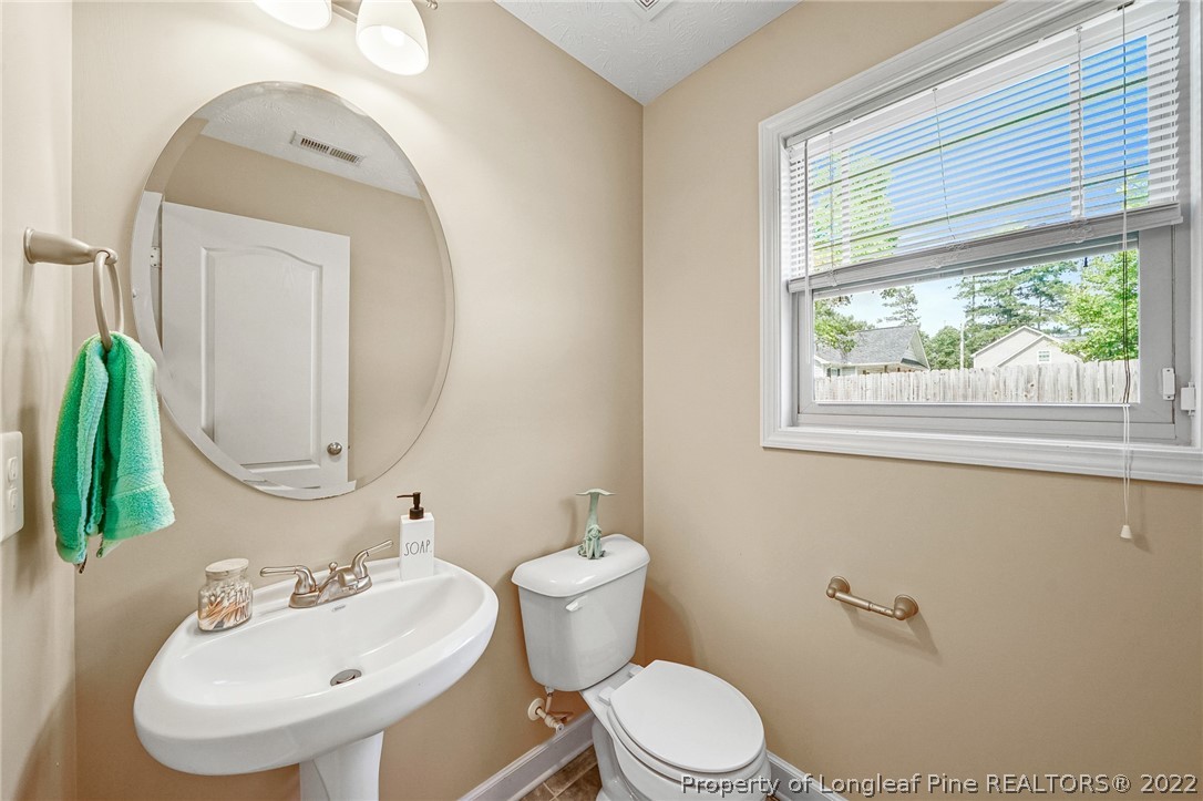 2673 Rockfish Road Raeford, NC 28376 - Photo 9 of 42 a bathroom with a toilet a sink and a mirror
