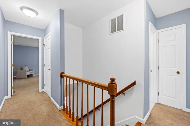 a view of a hallway with a livingroom and stairs