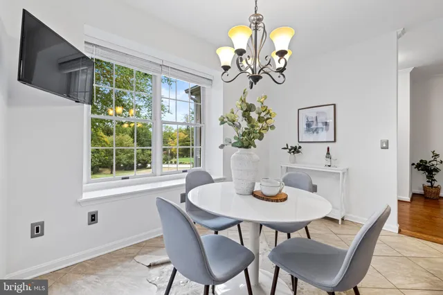 a view of a dining room with furniture a chandelier and wooden floor