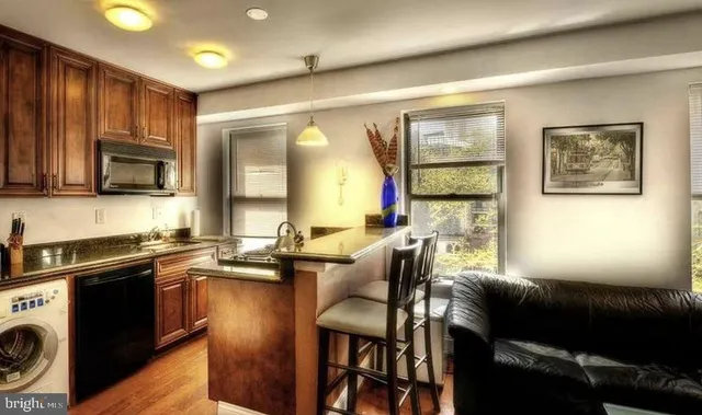 a kitchen with a table chairs microwave and cabinets
