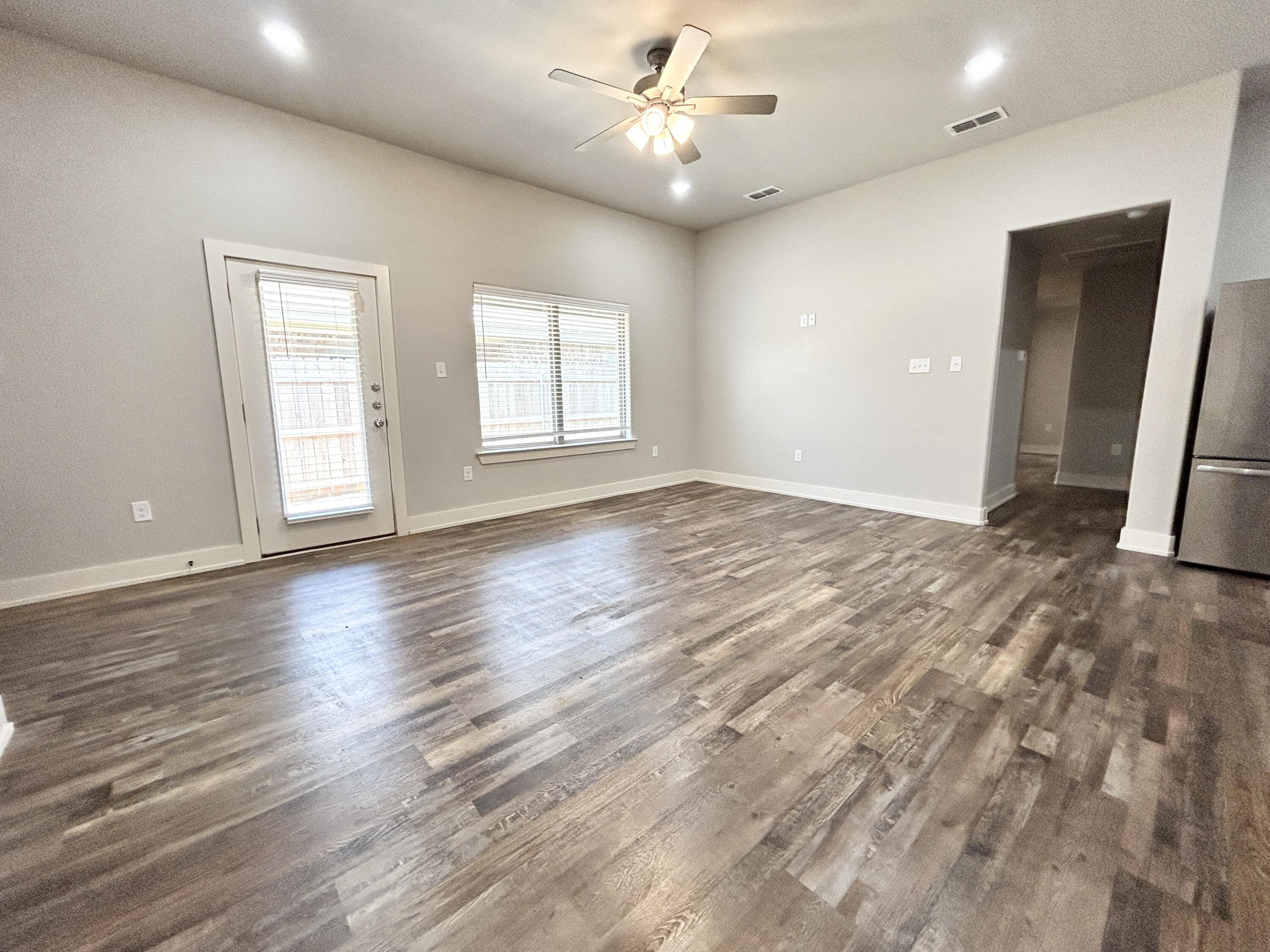 5512 122nd Street, Unit B Lubbock, TX 79424 - Photo 2 of 9 wooden floor in an empty room with a window