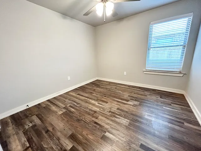 wooden floor in an empty room with a window