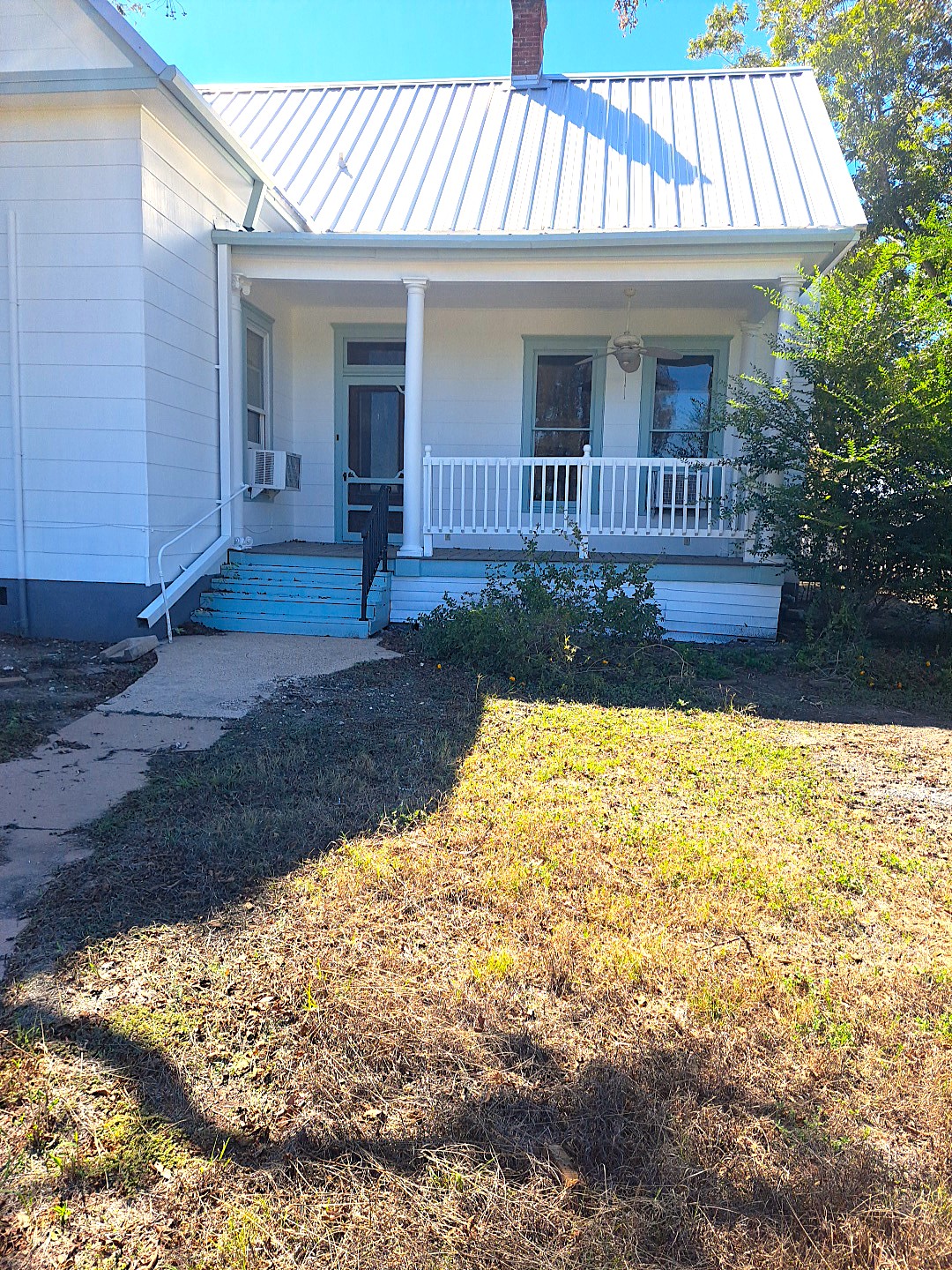 A welcoming front porch with classic columns and a durable metal roof creates timeless appeal.