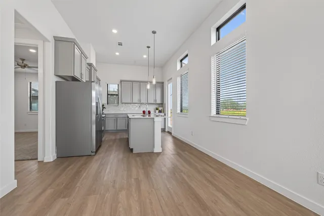 a view of a kitchen with wooden floor and electronic appliances