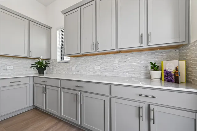 a kitchen with white cabinets and sink