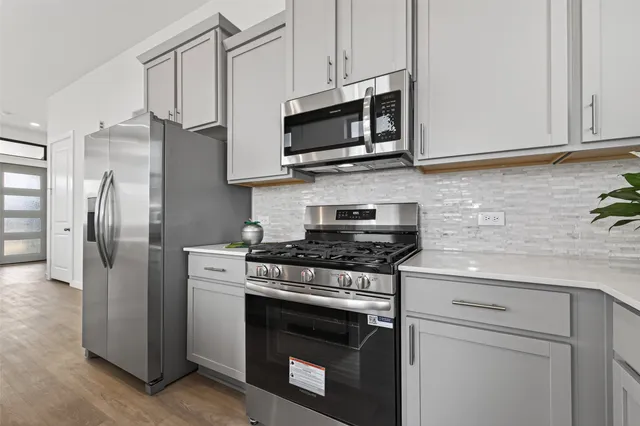 a kitchen with stainless steel appliances granite countertop a stove a refrigerator and a microwave