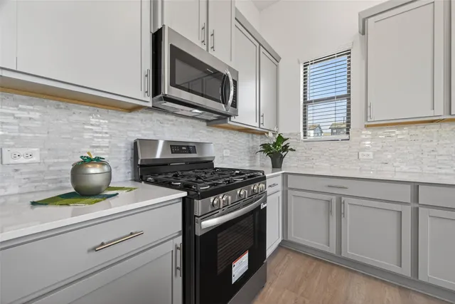 a kitchen with granite countertop a sink stainless steel appliances and cabinets