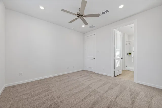 an empty room with a ceiling fan and a shower
