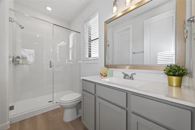 a bathroom with a sink a toilet and shower