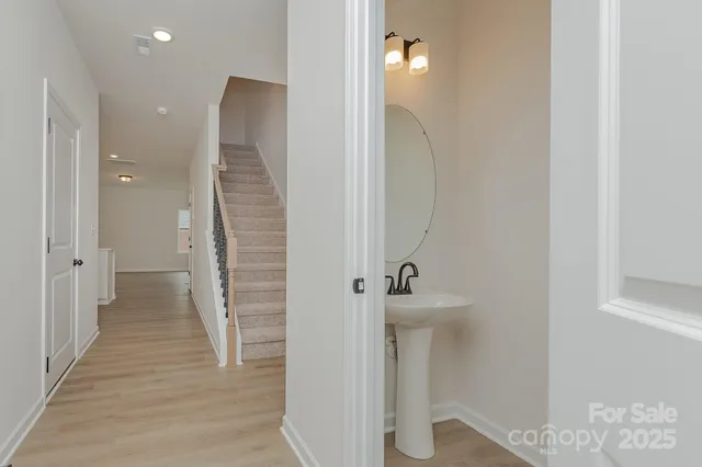 a large kitchen with stainless steel appliances a large counter top a sink a refrigerator and a window