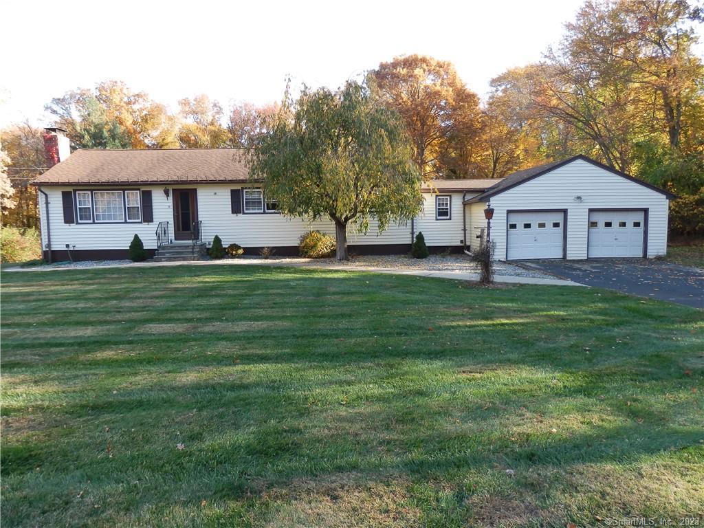 a front view of a house with a garden and trees