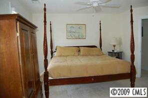 3444 Stettler View Road, Unit 225 Charlotte, NC 28210 - Photo 6 of 8 a bedroom with a bed and a painting on the wall