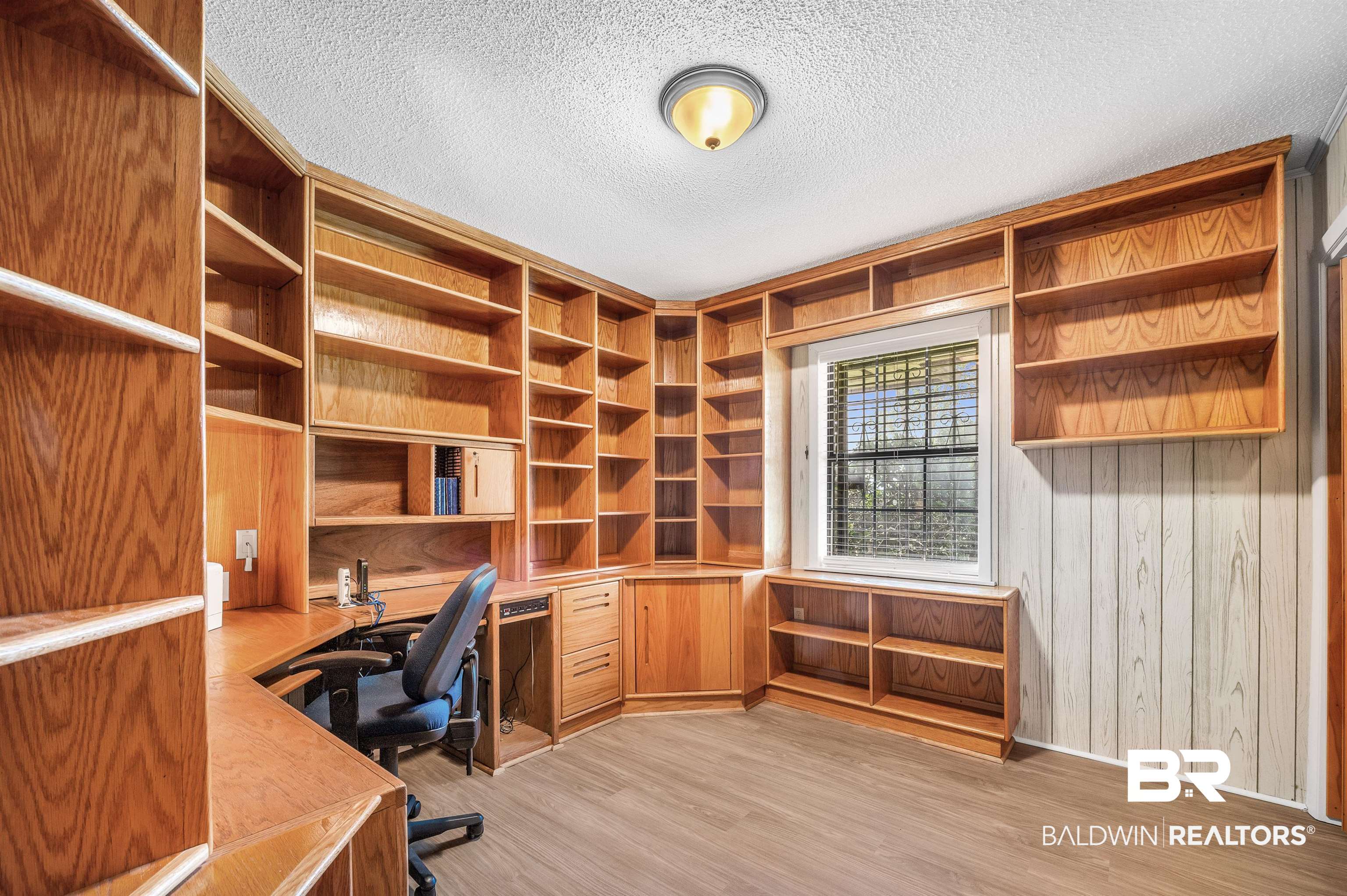 610 East Walker Avenue Foley, AL 36535 - Photo 23 of 38 Unfurnished office with built in desk, light wood-type flooring, a textured ceiling, and wood walls