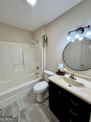 a spacious bathroom with a double vanity sink toilet mirror and bathtub