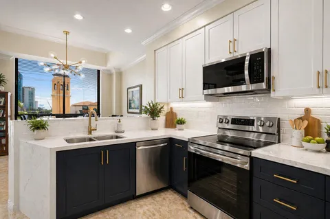 a kitchen with stainless steel appliances white cabinets white stove a microwave and a refrigerator