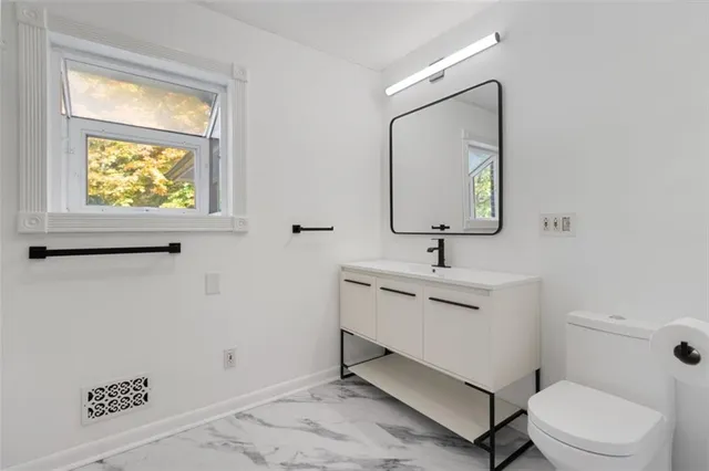 a bathroom with a sink mirror and toilet