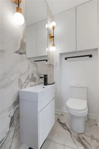a bathroom with a sink a toilet and mirror