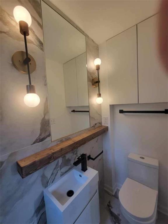 2958 Harcourt Drive, Unit 1 Decatur, GA 30033 - Photo 19 of 32 a bathroom with a sink a light fixture and a toilet