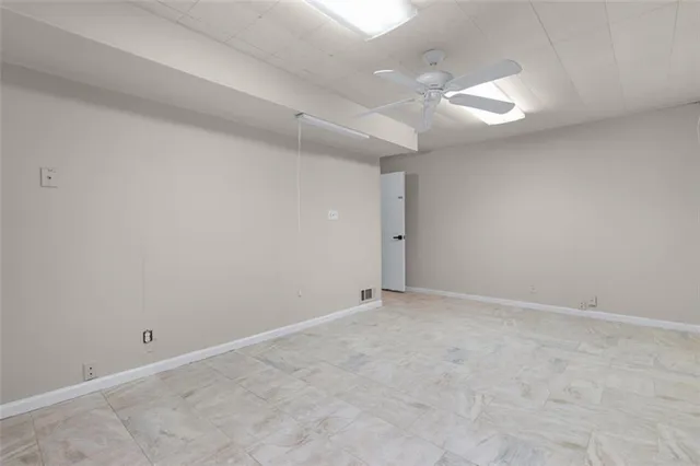 an empty room with a ceiling fan and window