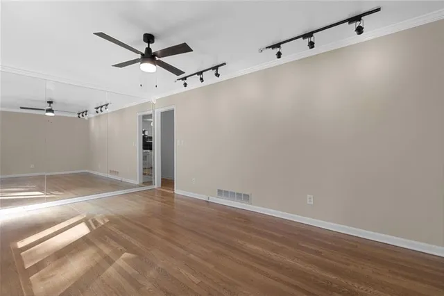 an empty room with wooden floor and windows